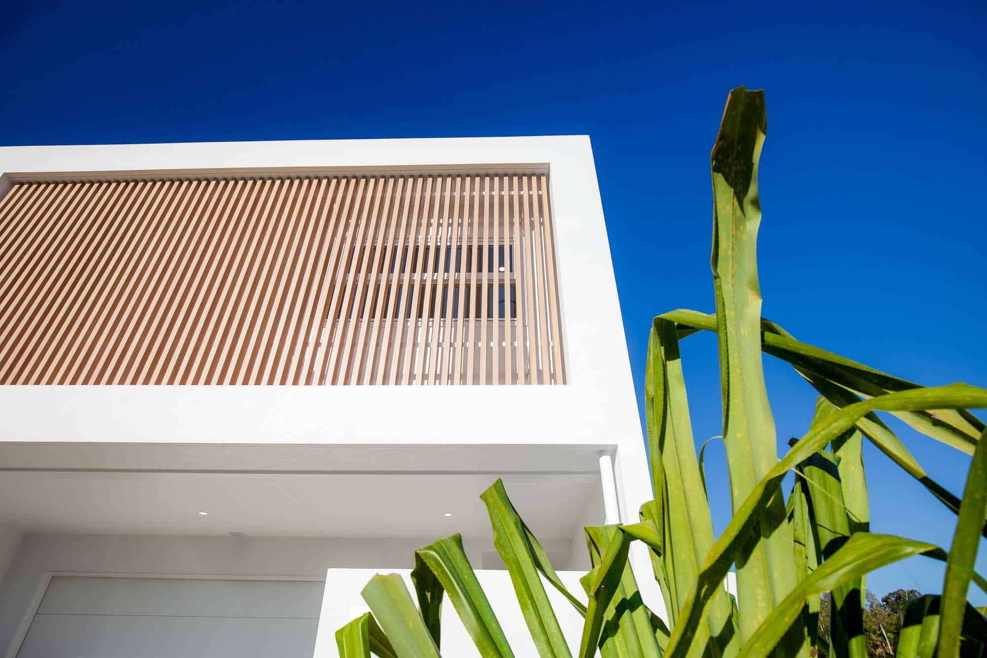 White coastal home with vertical timber battens
