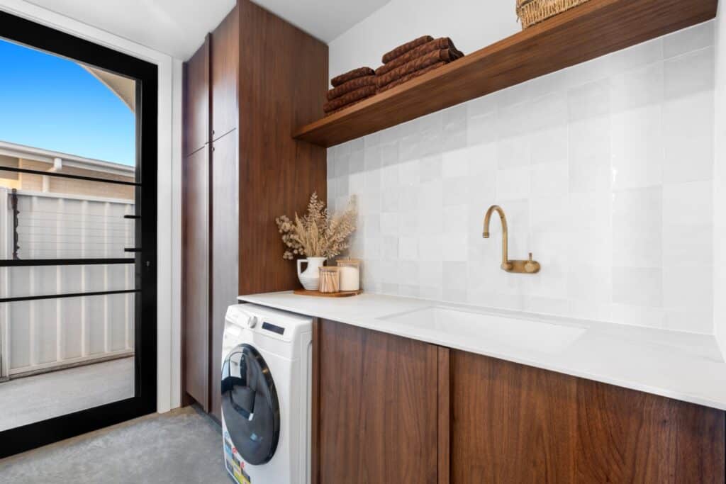 Laundry with timber cabinetry and brass tapware
