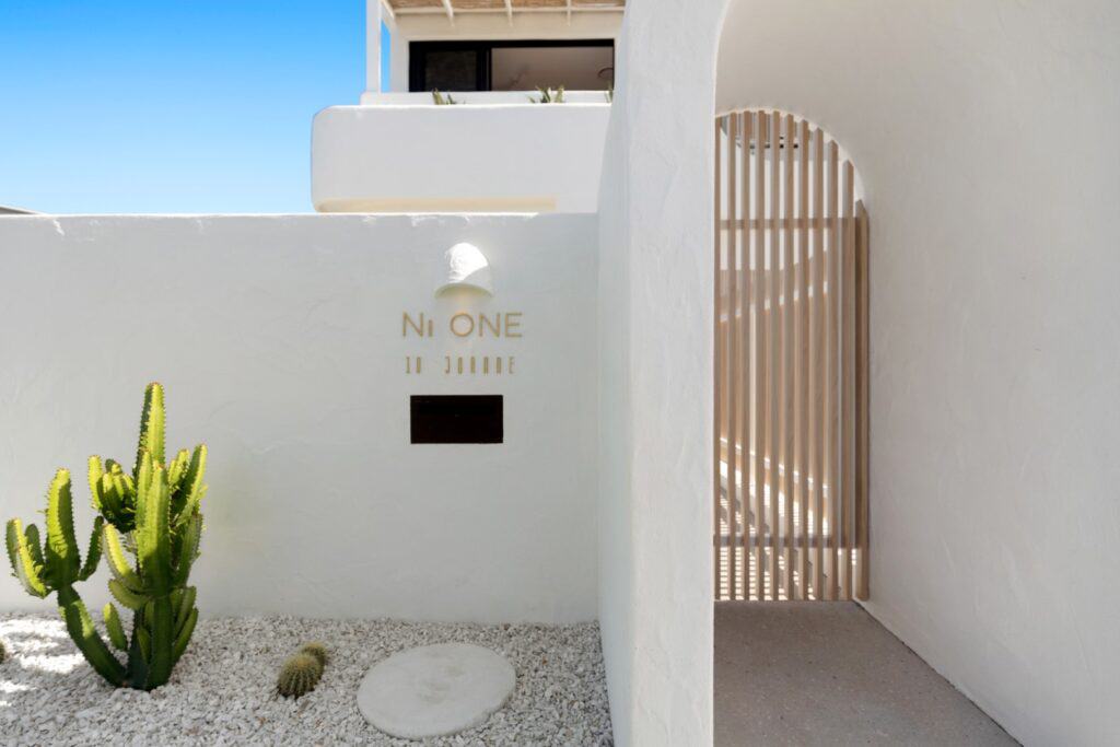 Arched courtyard wall with timber gate on a rendered townhouse